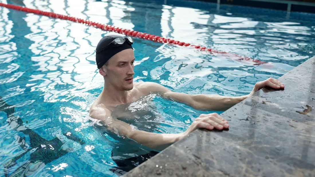 Coureur pédalant dans un bac d’eau, séance immersive en espace individuel, posture assise